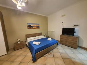 1 dormitorio con 1 cama y TV de pantalla plana en Maison Mael, en Scafati