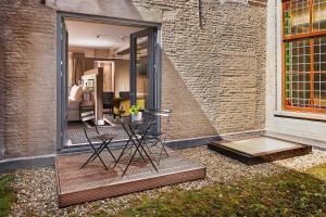 un patio con mesa y sillas junto a una pared de ladrillo en Hotel Nassau Breda, Autograph Collection en Breda