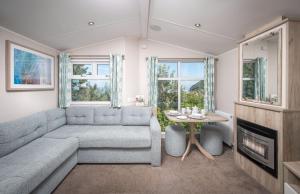 a living room with a couch and a table at Killigarth Manor Holiday Park in Polperro +29 photos