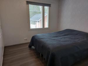Schlafzimmer mit einem Bett und einem Fenster in der Unterkunft Lomasara in Kalajoki
