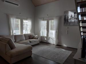 ein Wohnzimmer mit einem Sofa und 2 Fenstern in der Unterkunft Lomasara in Kalajoki