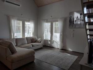 a living room with a couch and two windows at Lomasara in Kalajoki