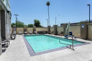 - une piscine dans un bâtiment avec des chaises dans l'établissement Hilton Garden Inn Phoenix Airport North, à Phoenix