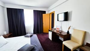 Habitación de hotel con cama, escritorio y silla en Hotel Eden en Sibiu
