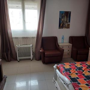 a bedroom with a bed and a couch and a chair at STATION KERDJOU TIARET in Tiaret