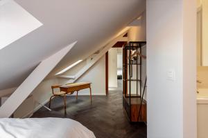 a bedroom with a bed and a desk and a staircase at Uma's Urban Lounge in Mechelen