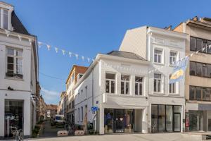 a white building on a city street with a banner at Uma's Urban Lounge in Mechelen