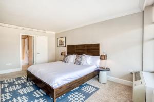 a bedroom with a bed and a lamp on a blue rug at CozySuites 800 Tower 2BR w sky pool gym 28 in Louisville