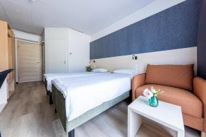 Habitación de hotel con cama y sofá en Saaremaa Rannahotell ' Beach Hotel en Mändjala