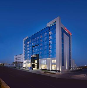 un grand bâtiment avec un panneau sur son côté dans l'établissement Hilton Garden Inn Tabuk, à Tabuk