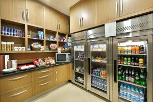 a kitchen with a refrigerator with drinks in it at Hilton Garden Inn Tabuk in Tabuk