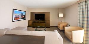 a living room with a couch and a flat screen tv at Embassy Suites by Hilton Seattle North Lynnwood in Lynnwood