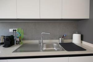 un bancone della cucina con lavello e armadietti bianchi di 220b - Casa Giulia, 3 camere da letto, 10 minuti dal mare a piedi a Sestri Levante