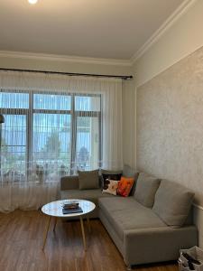uma sala de estar com um sofá e uma mesa em Villa SM em Baku