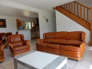 salon z 2 skórzanymi kanapami i stołem w obiekcie Maison 3 chambres 120m2 3km ploermel w mieście Ploërmel