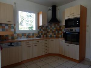a kitchen with wooden cabinets and a window in it at Maison 3 chambres 120m2 3km ploermel in Ploërmel
