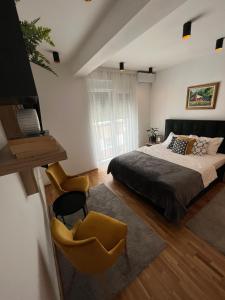 ein Schlafzimmer mit einem Bett und einem gelben Stuhl in der Unterkunft Magija in Vrnjačka Banja
