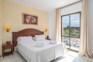 a bedroom with a bed and a large window at Apartahotel Playamaro by Dorobe in Maro +69 photos