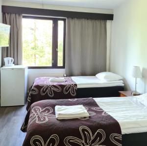 una camera d'albergo con due letti e una finestra di Hotel Julie a Joensuu