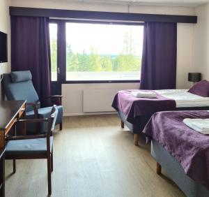 una camera d'albergo con due letti e una finestra di Hotel Julie a Joensuu