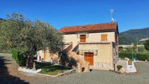 an old brick house with a tree in front of it at Spicchio di Luna - Casa Vacanze in Albiano