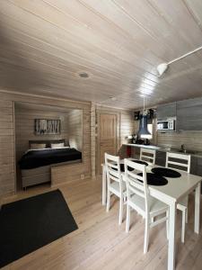 - une salle à manger avec une table, des chaises et un lit dans l'établissement LakeLodge Kiehinen & Igloos, à Rovaniemi