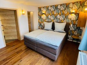 die Jungmühle في باد مونستريفل: غرفة نوم مع سرير بجدار ملون
