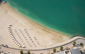 una vista aérea de una playa con coches aparcados en Hilton Doha The Pearl en Doha