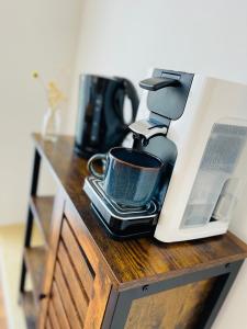a coffee maker and a cup on a counter at die Jungmühle in Bad Münstereifel