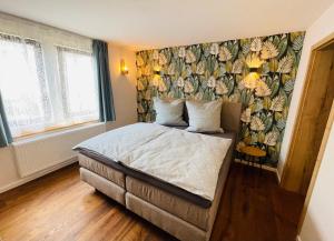 Schlafzimmer mit einem Bett mit Blumentapete in der Unterkunft die Jungmühle in Bad Münstereifel
