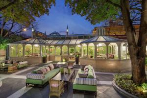 een patio met een tuinhuisje met banken en tafels bij Hagia Sofia Mansions Istanbul, Curio Collection by Hilton in Istanbul