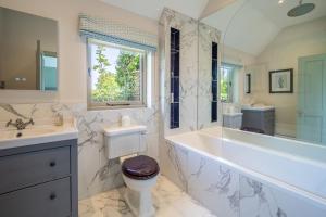 a bathroom with a tub and a toilet and a sink at Elegant luxurious cottage - The Dove House in Ipswich