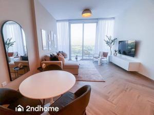 a large living room with a table and chairs at Homey 1 Bedroom with Relaxing Zabeel Park View in Dubai