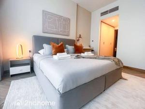 a bedroom with a large white bed with orange pillows at Homey 1 Bedroom with Relaxing Zabeel Park View in Dubai