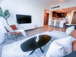 a living room with a couch and a table at Homey 1 Bedroom with Relaxing Zabeel Park View in Dubai