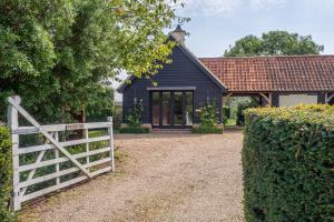ein blaues Haus mit einem weißen Zaun und einem Tor in der Unterkunft Elegant luxurious cottage - The Dove House in Ipswich