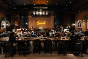 a group of people sitting at tables in a restaurant at EPISODE Hsinchu, JdV by Hyatt Hotel in Hsinchu City