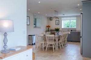 a kitchen and dining room with a table and chairs at Owls Nest Barn in Harescombe