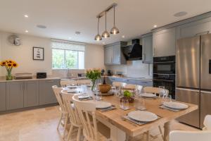 a kitchen with a wooden table and chairs in a kitchen at Owls Nest Barn in Harescombe