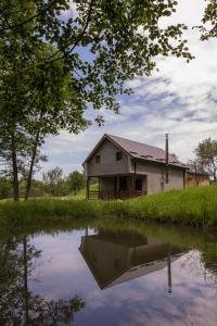 an old house sitting next to a body of water at Satul de vacanta Cuibul Lupilor in Ciucea