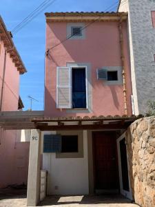 a pink and white house with a door and window at Casa Dúplex en Puerto de Alcudia in Alcudia