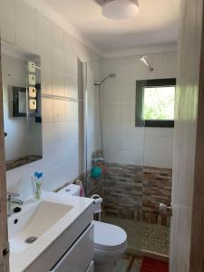 a bathroom with a white toilet and a sink at Casa Dúplex en Puerto de Alcudia in Alcudia