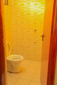 a bathroom with a white toilet in a room at Scindia Suites hotel in Jinja