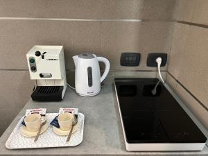 una macchinetta del caffè e tazze sedute su un bancone di Centrocentro Casa Vacanze ad Avellino