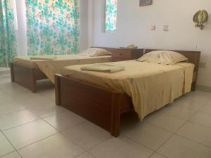 two twin beds in a room withermottermottermott at Residencial Pôr do Sol in Porto Novo