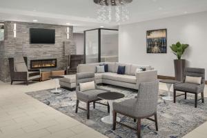 a living room with a couch and chairs and a fireplace at Homewood Suites By Hilton Greenville, NC in Greenville