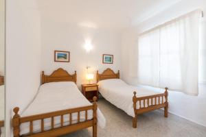 two twin beds in a bedroom with a window at Villa los brezos in Playa de Palma