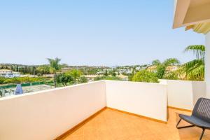 a room with a balcony with a chair at Villa Isabella in Albufeira