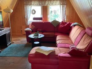 a living room with a red couch and a table at An der Heide. in Braunsteich