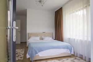 um quarto com uma cama com um cobertor azul e uma janela em Vila MOON em Bezdead